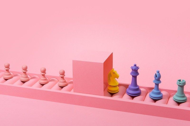 Pembe zemin üzerinde renkli satranç taşları